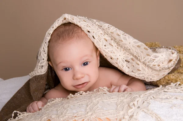 生まれたばかりの赤ちゃんの光の茶色の柔らかいふわふわ布に包まれました。 — ストック写真