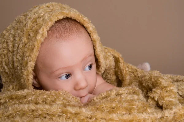 Nyfödda barnet insvept i ljus brun mjuk fluffig trasa — Stockfoto