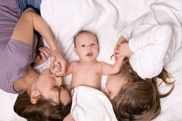 Maman, fille et fils couchés au lit — Photo