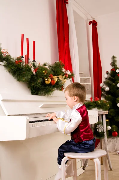 Niño tocando el piano en vísperas de Navidad — Foto de Stock