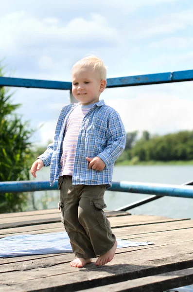 Jongen op de oever van de rivier — Stockfoto