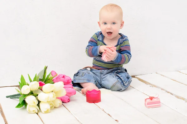 Boy sitting on floor of  white planks — Stock Photo, Image