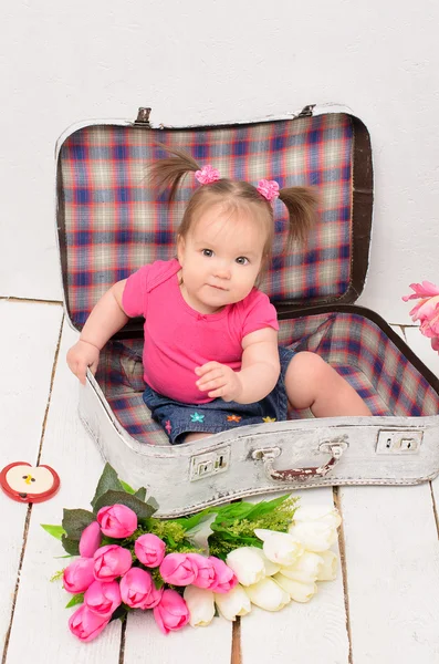 Baby girl sitting in old vintage suitcases — Stock Photo, Image