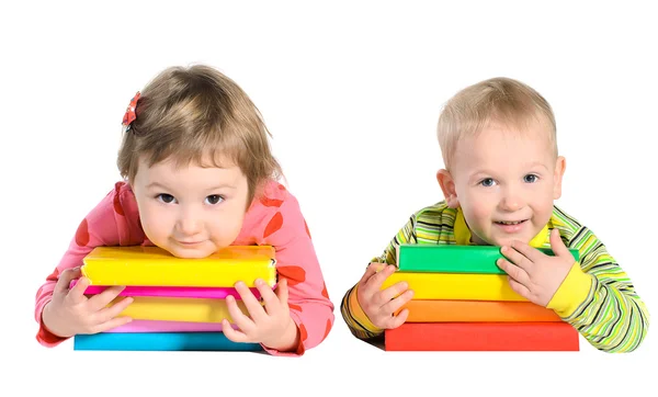 Petit garçon et petite fille avec des piles de livres — Photo