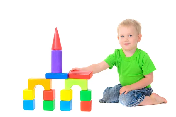 Хлопчик будує будівлю з кольорових кубиків — стокове фото