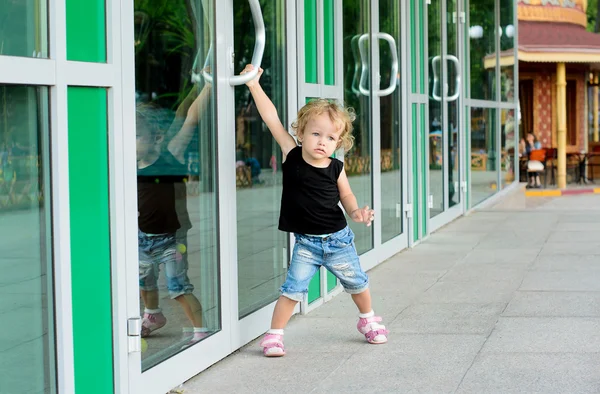 Girl trying to open the doors — Stock Photo, Image
