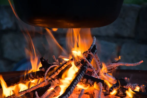 Kamp ateşinin üzerinde buharlı çaydanlık, ateş kasesinin üstünde çaydanlık.