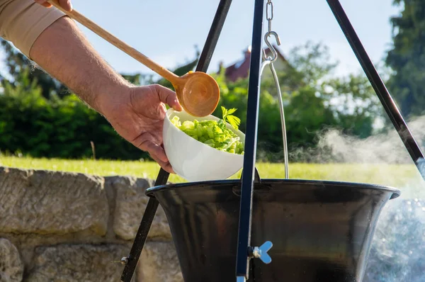 Kamp ateşinin üzerinde buharlı çaydanlık, ateş kasesinin üstünde çaydanlık.
