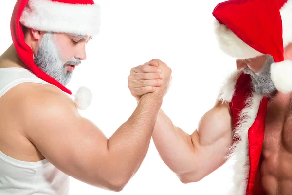 Navidad. Retrato de cerca de dos serias Santa Claus musculosas confiadas que realizan técnicas de lucha libre de brazos aisladas sobre fondo blanco — Foto de Stock