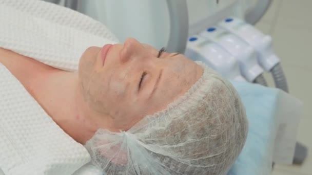 Косметологическая процедура. Женщина закрывает глаза клиента перед процедурой пилинга углерода в салоне красоты. — стоковое видео