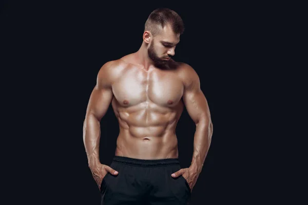 筋肉質でフィット若いボディビルダーフィットネス男性モデルポーズ黒の背景に隔離 — ストック写真