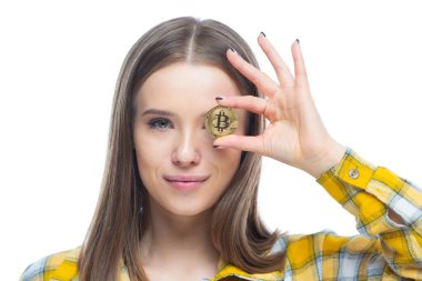 Gülümseyen genç bir kadının gözünün önünde bitcoin tutan portresini yakından çek. Parlak gelecek kavramı, zenginlik, yenilik, yatırım
