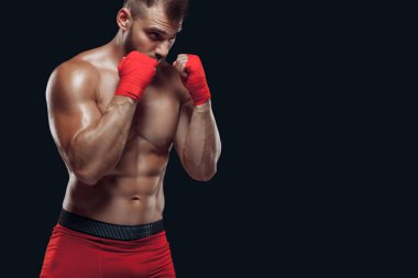 Siyah arka planda izole edilmiş dövüş teknikleri uygulayan boks eldivenli bir adamın yakın görüntüsü.