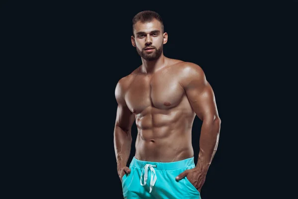 Spieren en fit jonge bodybuilder fitness mannelijk model poseren over geïsoleerde zwarte achtergrond — Stockfoto