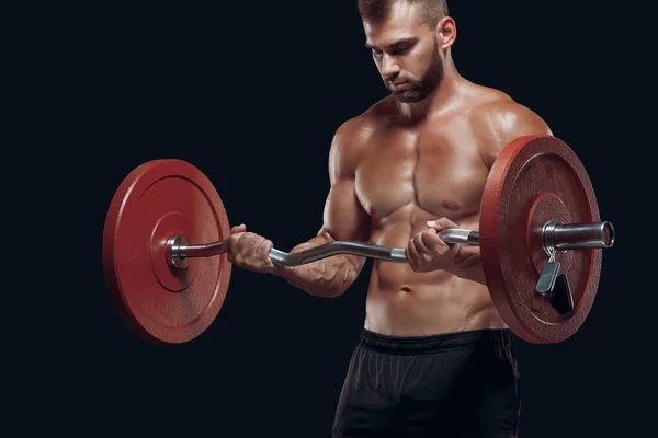 Front view of a strong man bodybuilder exercising with a barbell isolated on black background — Stock Photo, Image