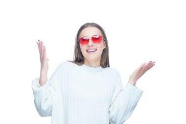 Kırmızı güneş gözlüklü, beyaz arka planda elleri havada duran çekici bir kadının stüdyo portresi.