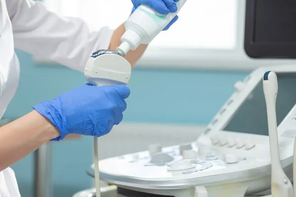 Närbild av tillämpningen av medicinsk gel på ultraljud diagnostisk sensor. Läkaren förbereder sig för ultraljudsproceduren — Stockfoto