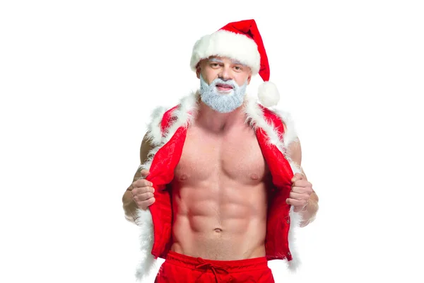 Christmas. Portrait of muscular sexy strong athlete in Santa Claus costume with gray beard posing showing his abs isolated on white background — Stock Photo, Image