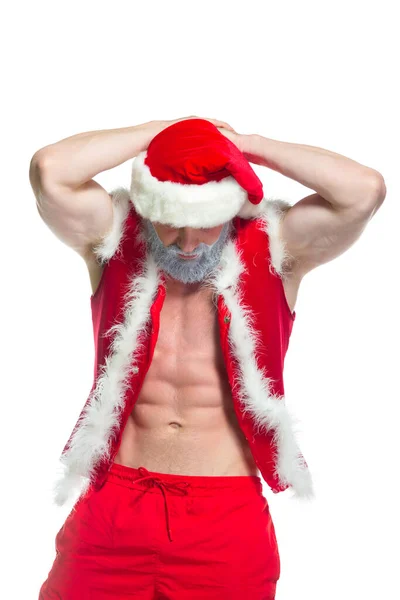 Natale. Ritratto di atleta muscoloso sexy forte in costume da Babbo Natale con barba grigia in posa mostrando i suoi addominali isolati su sfondo bianco — Foto Stock