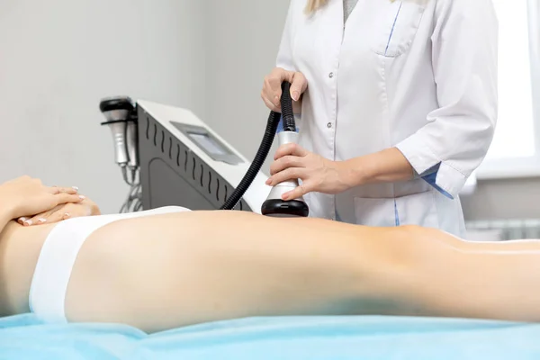 Smal kvinna får en kavitation förfarande att få anti-celluliter och anti-fett terapi på hennes tighta skinkor i en skönhetssalong för att dela fettceller under påverkan av ultraljud från en — Stockfoto