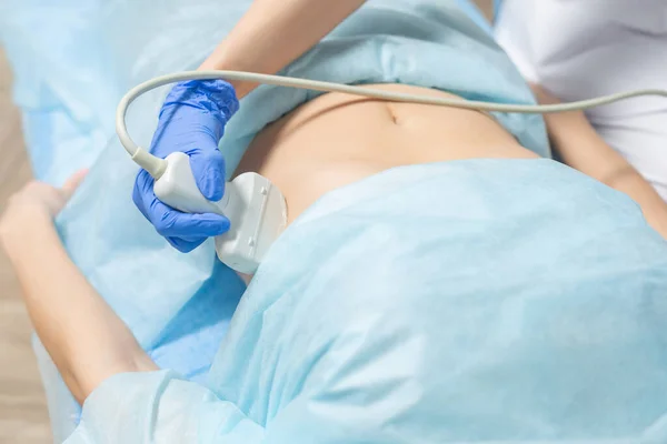 Fotografering av läkare som flyttar ultraljudssonden på gravid kvinna mage under en planerad tid — Stockfoto
