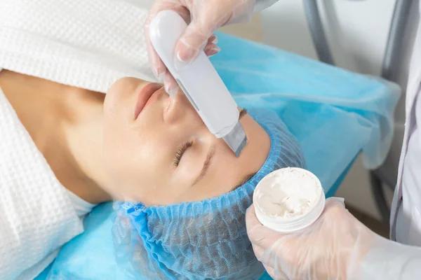 Ultradźwiękowe oczyszczanie twarzy wykonywane przez profesjonalnego kosmetologa w salonie piękności. Delikatnie złuszcza górną warstwę skóry, sprzyja lepszej penetracji składników odżywczych i produktów leczniczych — Zdjęcie stockowe