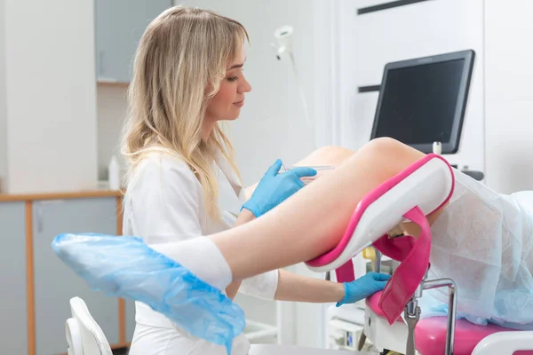En gynekolog gör en rutinundersökning av en flicka på en gynekologisk stol med hjälp av modern medicinsk teknik — Stockfoto