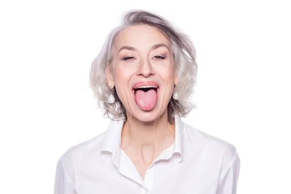 Aufnahme einer schönen reifen Frau, die Spaß hat und ihre Zunge isoliert auf weißem Hintergrund herausstreckt — Stockfoto