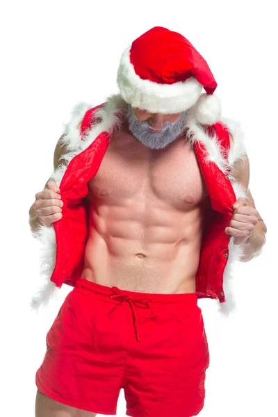Navidad. Retrato de atleta musculoso sexy fuerte en traje de Santa Claus con barba gris posando mostrando sus abdominales aislados sobre fondo blanco — Foto de Stock