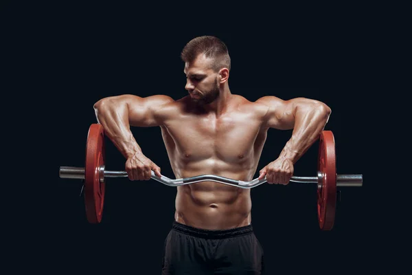 Front view of a strong man bodybuilder lifting a barbell isolated on black background — Stock Photo, Image