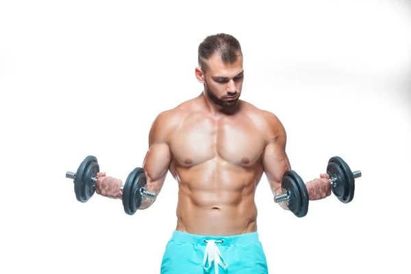 Sexy atlético homem está mostrando corpo muscular com halteres de pé com a cabeça para baixo, isolado sobre fundo branco — Fotografia de Stock
