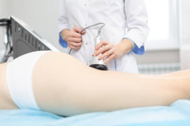 Rahatlamış bir kadının kaplıca merkezinde sonosferleri kaldırırken çekilmiş yakın plan bir fotoğrafı. Kas dokularının derin ısınması nedeniyle, hızlı ve istikrarlı bir kaldırma etkisine ulaşılır.