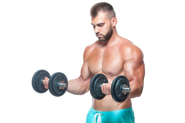 Sexy atlético hombre está mostrando cuerpo muscular con mancuernas de pie con la cabeza hacia abajo, aislado sobre fondo blanco — Foto de Stock