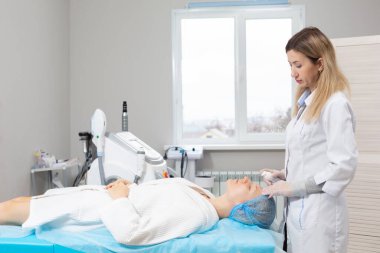 Güzellik salonunda genç bir kadının yüzü. Cilt yenilenmesi ve nemlendirici işlemler için yüz bakımı için pamuk pedlerin kullanılması