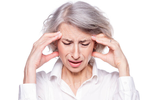 Портрет старой, но современной модной женщины, страдающей головной болью или мигренью, держащей голову в руках с отчаянным выражением лица и кричащей от боли, изолированной на белом фоне