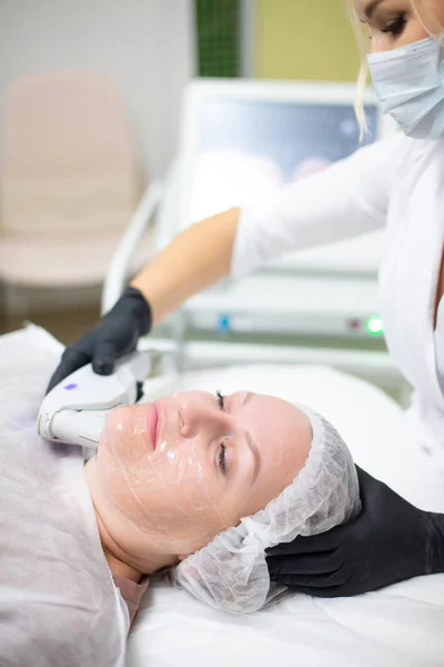Kobieta w gabinecie kosmetologii przechodzi zabieg podnoszenia SMAS. Niechirurgiczne podnoszenie twarzy, odmładzanie, nawilżanie, usuwanie zmarszczek, odcień i elastyczność skóry — Zdjęcie stockowe