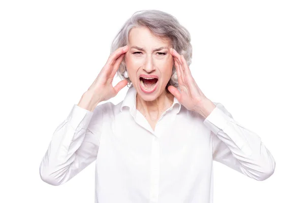 Studio shot of distressed irritated senior woman losing temper screaming out loud from pain and holding hands on head troubled and concerned being pissed and fed up, isolated on white background — Fotografia de Stock