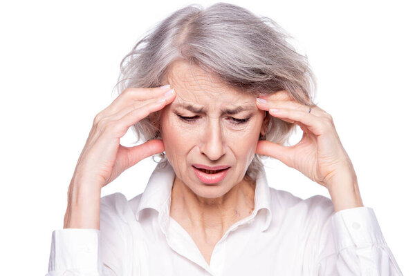Портрет старой, но современной модной женщины, страдающей головной болью или мигренью, держащей голову в руках с отчаянным выражением лица и кричащей от боли, изолированной на белом фоне