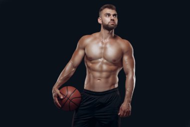 Siyah arka planda basketbol oynayan kaslı çıplak bir adamın portresi.