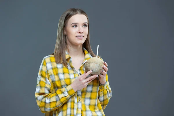 ココナッツと藁を手にした美しい若い女性の肖像画。健康的なライフスタイル、適切な栄養、食事、ビーガン、ベジタリアンの概念 — ストック写真