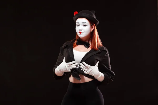Portret van vrouwelijke mime artiest optredend, geïsoleerd op zwarte achtergrond. Vrouw raakt haar borst met zelfverzekerde blik. Symbool van borstvergroting, groot formaat — Stockfoto
