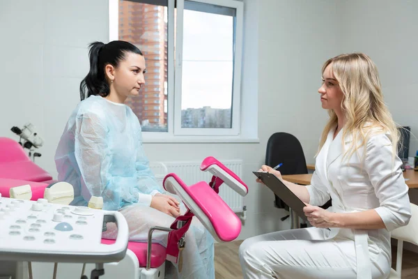 Foto av en gynekolog läkare och en patient på en gynekologisk stol. Förebyggande mottagning, förberedelse för medicinsk undersökning, graviditetshantering, hälsovård gynekologi kontol — Stockfoto