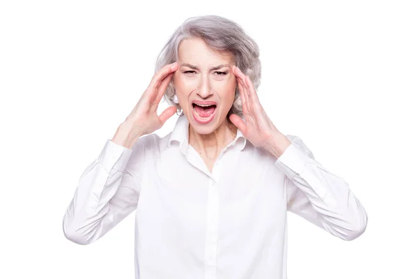 Studio shot of distressed irritated senior woman losing temper screaming out loud from pain and holding hands on head troubled and concerned being pissed and fed up, isolated on white background — ストック写真