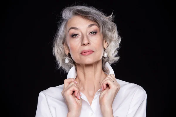 Una imagen de una mujer adulta madura y segura de sí misma de pelo gris aislada sobre un fondo negro —  Fotos de Stock