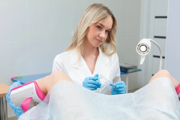Ein Gynäkologe führt in einer modernen Arztpraxis eine Kolposkopie an einem jungen Mädchen auf einem gynäkologischen Stuhl durch. Prävention und Diagnose von Gebärmutterhalskrebs — Stockfoto