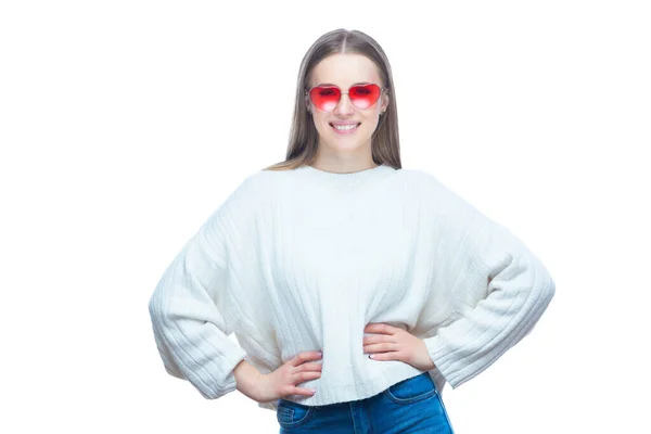 Portrait of pretty happy laughing woman in the red sunglasses standing with her hands on her hips isolated on white background — Stock Photo, Image