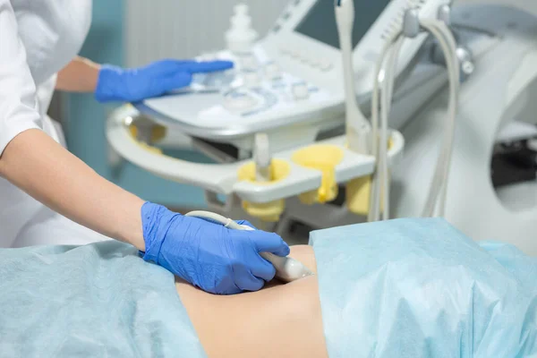 Fotografie eines Arztes, der eine Ultraschallsonde auf dem Bauch einer schwangeren Frau während eines geplanten Termins bewegt — Stockfoto