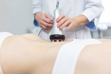 Rahatlamış bir kadının kaplıca merkezinde sonosferleri kaldırırken çekilmiş yakın plan bir fotoğrafı. Kas dokularının derin ısınması nedeniyle, hızlı ve istikrarlı bir kaldırma etkisine ulaşılır.