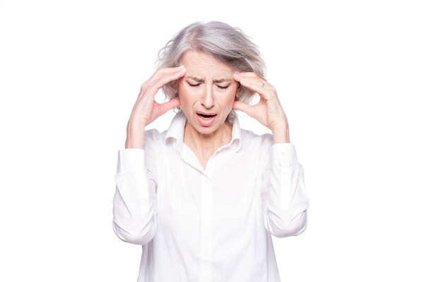 Портрет старой, но современной модной женщины, страдающей головной болью или мигренью, держащей голову в руках с отчаянным выражением лица и кричащей от боли, изолированной на белом фоне