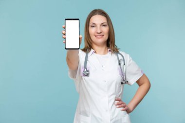 Mavi arka planda akıllı telefonu olan bir kadın doktor. Reklam için yer var. Kopyala yapıştır. sağlık hizmeti kavramı.